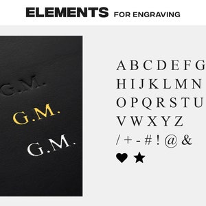 May include: A black leather surface with the initials "G.M." engraved in gold and silver. The image also shows a list of letters, numbers, and symbols that can be used for engraving.