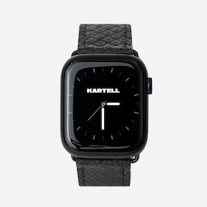 Op de afbeelding: Een zwarte smartwatch met een zwarte leren band. De wijzerplaat van het horloge is zwart met witte wijzers en het woord "KARTELL" staat in wit gedrukt.