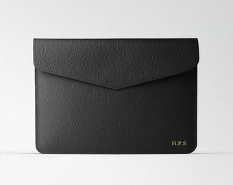 May include: Black leather envelope clutch with a flap closure and the initials "H.P.S." embossed in gold.