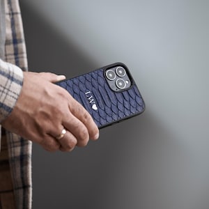 May include: A navy blue phone case with a snakeskin pattern and a white heart with the initials "LW" on it.
