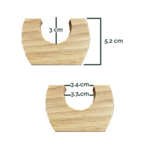 May include: Two light-colored wooden U-shaped holders with visible grain. The top piece shows a height of 3 cm and 5.2 cm. The bottom piece shows internal widths of 3.4 cm and 3.7 cm. These wooden components feature a flat base and a curved cutout.