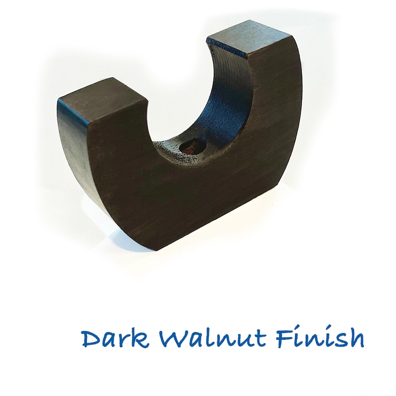 May include: A dark brown, crescent-shaped wooden object with a smooth finish and a central circular cutout. The object is positioned upright, and the text "Dark Walnut Finish" is printed in blue below the item on a plain white background.