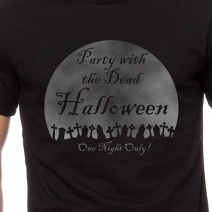 May include: Black t-shirt with a graphic of a full moon and the text "Party with the Dead Halloween One Night Only!" with a row of tombstones at the bottom.