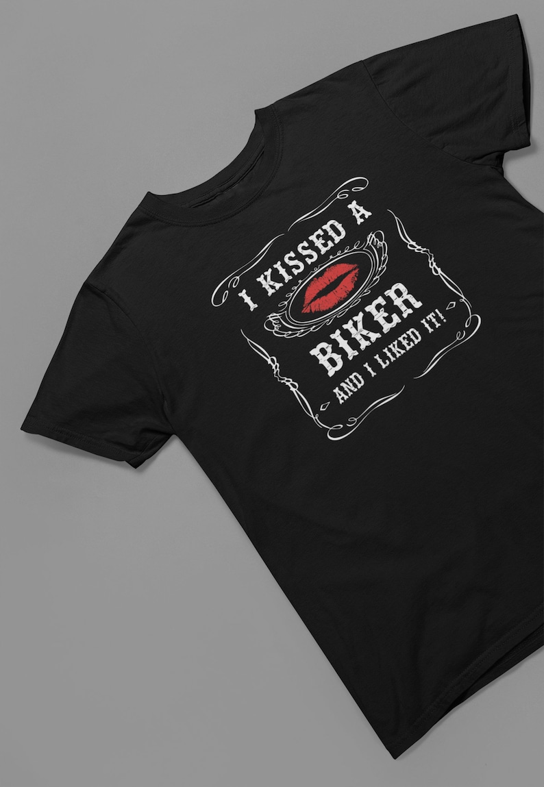 Peut inclure: T-shirt noir avec un motif graphique blanc qui dit "J'ai embrass&eacute; un motard et j'ai aim&eacute; &ccedil;a !" avec une empreinte de rouge &agrave; l&egrave;vres rouge.