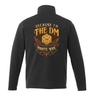 May include: Black long-sleeve shirt with a gold design featuring a 20-sided die and the text "Because I'm The DM That's Why."