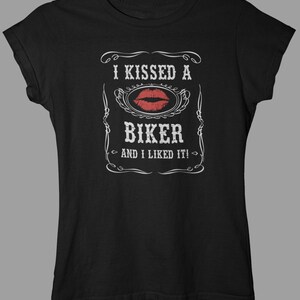 Peut inclure: T-shirt noir avec un motif graphique blanc qui dit "J'ai embrass&eacute; un motard et j'ai aim&eacute; &ccedil;a !" avec une empreinte de rouge &agrave; l&egrave;vres rouge.