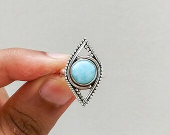 May include: A silver ring with a blue gemstone set in a diamond-shaped design.