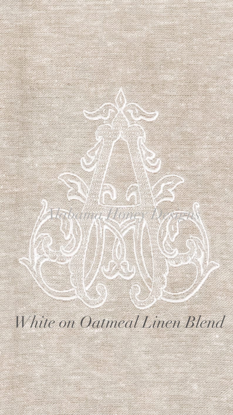 May include: White embroidered letter A on an oatmeal linen blend fabric. The letter is in a decorative script font with flourishes.