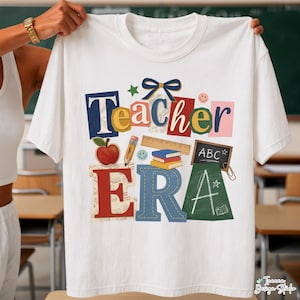 Może przedstawiać: Biała koszulka z kolorowym wzorem "Teacher Era". Wzór zawiera słowo "Teacher" w różnych kolorach i czcionkach, a także grafikę o tematyce szkolnej, taką jak jabłko, ołówek, linijka i książki.