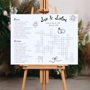 Puede incluir: Un letrero blanco sobre un caballete de madera con un crucigrama titulado "Sip & Solve" para la boda de Christina & Liam el 03 de junio de 2030. El rompecabezas incluye pistas relacionadas con la boda.