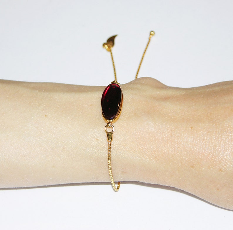 Red baltic amber and gold plated sterling silver charm bracelet