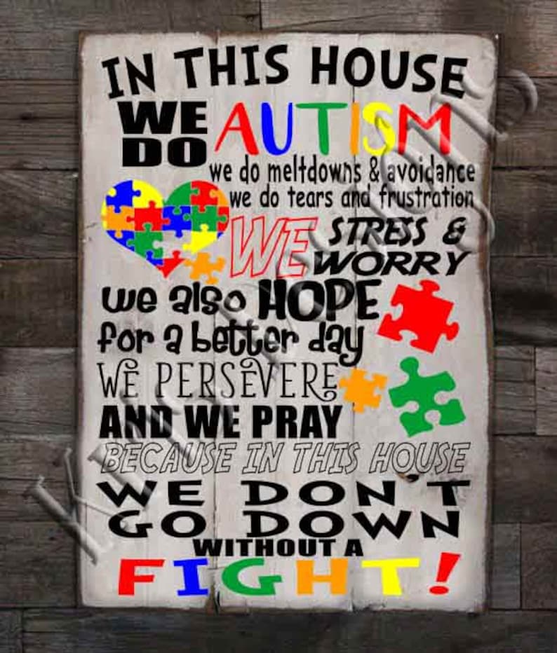 May include: A white wooden sign with the text "In this house we do autism" in black letters. The text "we do meltdowns & avoidance, we do tears and frustration" is in smaller black letters. The text "we stress & worry" is in black letters. The text "we also hope for a better day, we persevere and we pray because in this house we don't go down without a fight!" is in black letters. The sign is decorated with colourful puzzle pieces.