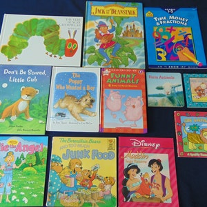 May include: A collection of children's books featuring various themes, including animals, fairy tales, and educational topics. The books have colorful covers with illustrations of a caterpillar, a puppy, pigs, farm animals, a lion, and a genie.