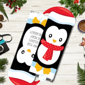 May include: Two chocolate bar wrappers with cartoon penguin designs. One penguin wears a Santa hat and red scarf. The other wrapper has the text "MAY YOUR HOLIDAYS BE MERRY AND BRIGHT!" on it. The wrappers are black with white and yellow accents.