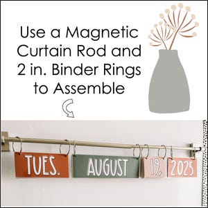 This image shows a magnetic rod holding a flip calendar in a neutral boho theme.