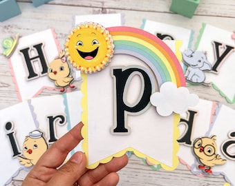 May include: A colorful banner with the letter "P" in the center, a rainbow, a sun with a smiley face, and a cloud. The banner is decorated with scalloped edges and yellow trim. The banner is part of a larger set of letters that spell out "Happy Birthday".