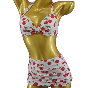 May include: White cherry print bikini top and high-waisted skirt with red cherries.
