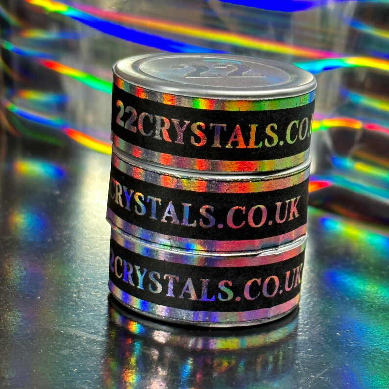 May include: Three silver containers with holographic labels stacked on top of each other. The labels are black with white text that reads "22crystals.co" and "crystals.co.uk".