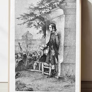 Puede incluir: Impresión enmarcada en blanco y negro de una escena histórica. Un hombre con uniforme militar está de pie cerca de un muro, con una multitud y edificios al fondo. La impresión incluye texto en la parte inferior: "BONAPARTE, LIEUTENANT D'ARTILLERIE, AUX TUILERIES (10 AOUT 1792)".