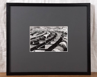 Fotografia di un deposito ferroviario degli anni '70, vagoni merci in bianco e nero, arte urbana minimalista da parete.