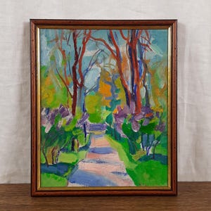 Könnte beinhalten: Ein impressionistisches Gemälde eines Weges durch einen Park, gerahmt in dunklem Holz. Das Kunstwerk zeigt einen Weg in der Mitte, flankiert von grünem Laub, rot-orangen Bäumen und lila Blumen. Der Himmel ist hellblau.