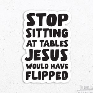 May include: A white sticker with black text that reads "STOP SITTING AT TABLES JESUS WOULD HAVE FLIPPED." The sticker has a black border and the text is in a bold, sans-serif font. The sticker also includes the artist's name and website.