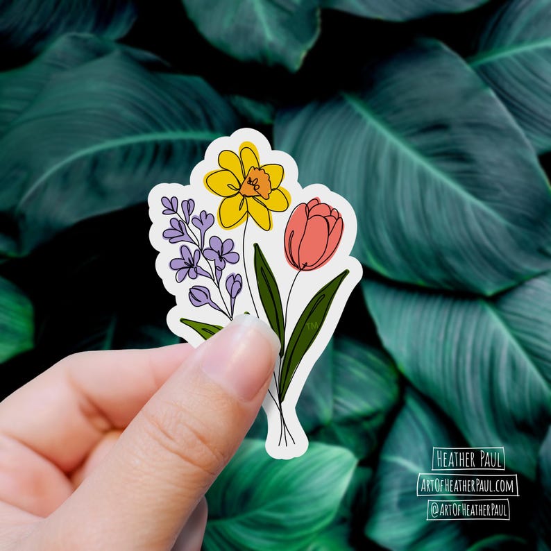 sticker featuring a purple freesia, a yellow daffodil with and orange center and a  pinkish-red tulip over a background with green leaves