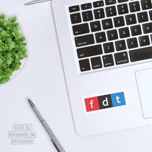 sticker featuring parody of the NPR logo with the letters fdt mocked up on a laptop computer