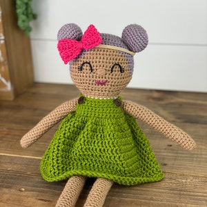 Crochet doll wearing a green dress, pink shoes and purple hair. Listing is for a crochet doll pattern and not the finished piece.