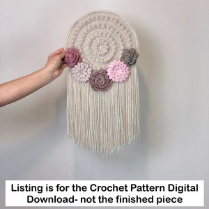 Puede incluir: Un tapiz de pared de ganchillo con un c&iacute;rculo beige y flores rosas y grises. La oferta es para el patr&oacute;n de ganchillo digital para descargar, no para la pieza terminada.