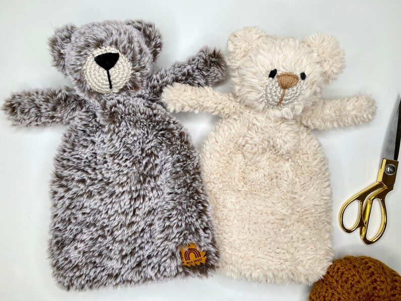 以下が含まれることがあります： 2つのぬいぐるみテディベアセキュリティブランケット、1つは茶色と白、もう1つは白。茶色と白のクマは胸に「Wild & Free」と書かれた虹のロゴが付いています。