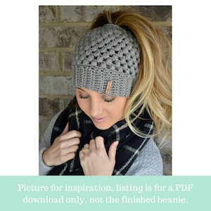 crochet messy bun beanie modeled by beautiful blond woman in the color dark gray