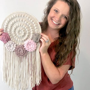 Puede incluir: Un patr&oacute;n de crochet para una pared colgante con un dise&ntilde;o circular y flores rosas. El patr&oacute;n incluye instrucciones para crear un borde de flecos. La lista es para la descarga digital del patr&oacute;n de crochet - no la pieza terminada.
