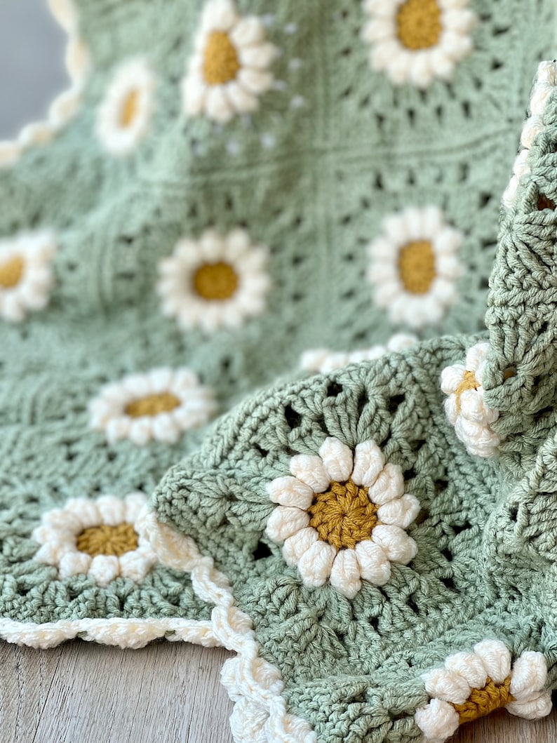 Daisy granny square blanket with a green background, white petals, and a yellow center. The listing is for a digital download crochet pattern and not the finished blanket.