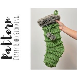 May include: Green crocheted Christmas stocking with a faux fur cuff and a pom-pom. The stocking is hanging from a loop at the top. "Crafty Boho Stocking" is written in black text on a white background.