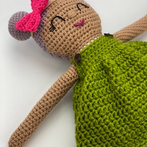 Crochet doll wearing a green dress, pink shoes and purple hair. Listing is for a crochet doll pattern and not the finished piece.