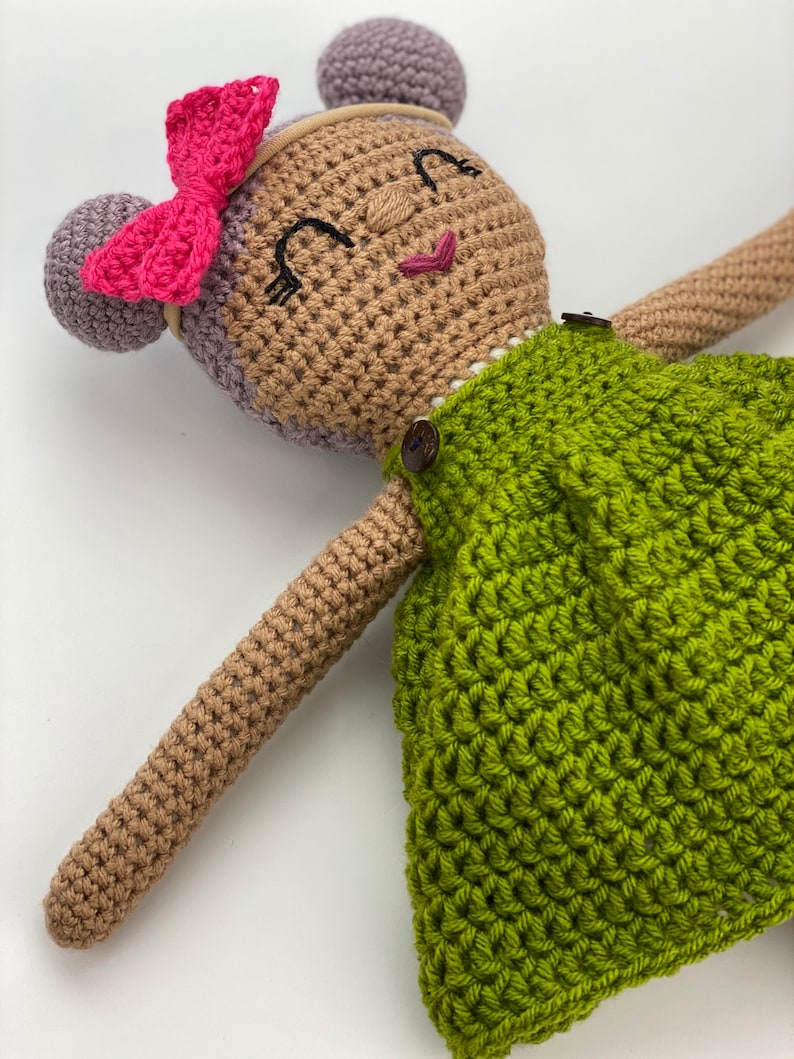 Crochet doll wearing a green dress, pink shoes and purple hair. Listing is for a crochet doll pattern and not the finished piece.