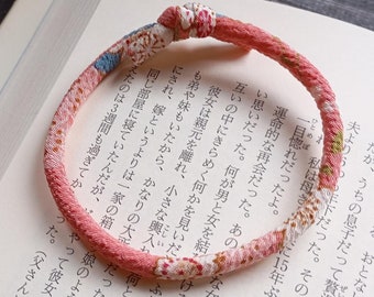 Pulsera Sakura Rosa: Tejido tipo kimono, lavable, ajustable y cómoda.