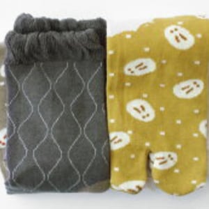 Peut inclure: Deux paires de chaussettes. Une paire est gris foncé avec un motif de losanges blancs et un bord texturé. L'autre paire est jaune moutarde avec un motif blanc et marron et un design à bout fendu.