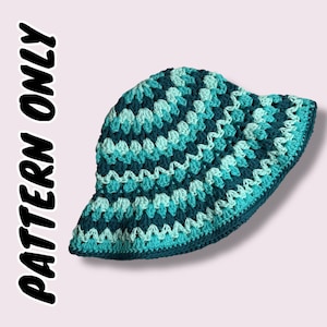 May include: A handmade crochet bucket hat in shades of teal and turquoise. The hat features a textured stitch pattern and a wide brim. The text "PATTERN ONLY" is printed on the left side of the image.