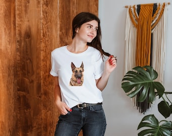 May include: A white t-shirt featuring a brown and black German Shepherd dog graphic on the front. The dog is looking at the camera with its tongue sticking out.