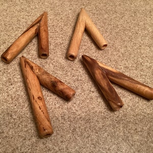 May include: Four wooden Y-shaped objects with a smooth, polished finish. The objects are made of light brown wood with darker brown streaks.
