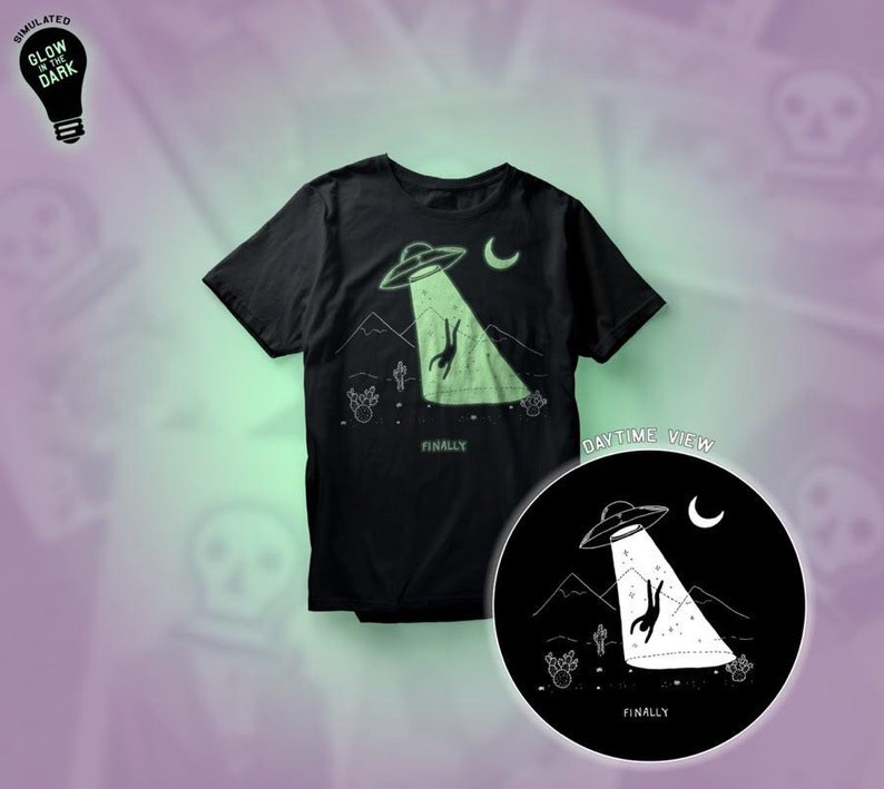 May include: Black t-shirt with a glow-in-the-dark design of a UFO abducting a person. The design includes the text "Finally" and "Daytime View".