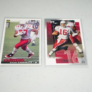 May include: Two trading cards of Arizona Cardinals football players. The card on the left features Larry Centers, a running back, wearing a red jersey with the number 37. The card on the right features Jake Plummer, a quarterback, wearing a red jersey with the number 16.