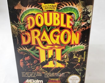 May include: A Double Dragon III video game box. The box features a vibrant illustration with a green dragon, martial arts figures, and the game title in large yellow letters. The text reads "The Greatest Martial Arts Adventure Series Ever!"