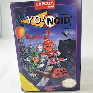 May include: A purple, blue, and red Nintendo game cartridge box for the game "Yo! Noid" by Capcom. The box features a cartoon character with a red suit and a green character with a green suit. The box also features the text "Pizza Crusher" and the Nintendo Seal of Quality.