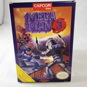 May include: A box for the Mega Man 3 video game for the Nintendo Entertainment System. The box is purple and features a picture of Mega Man fighting a robot. The text on the box reads "CAPCOM USA MEGA MAN 3".