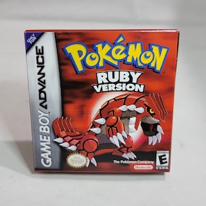 May include: A red Game Boy Advance game cartridge for Pokemon Ruby Version. The front of the box features a red, spiky Pokemon with yellow eyes. The text "Pokemon Ruby Version" is printed in yellow and blue on a red background. The text "Game Boy Advance" is printed on the side of the box in white.