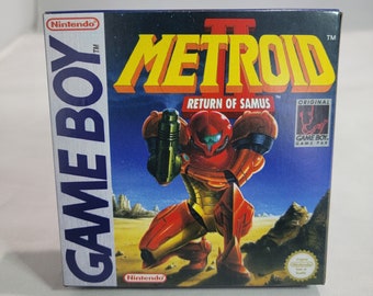 May include: A blue Game Boy cartridge case with a red and yellow Metroid II: Return of Samus game title. The front of the case features a red and green illustration of Samus Aran, the protagonist of the game, holding a weapon.