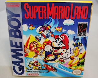 May include: A yellow, blue, and red Game Boy cartridge box with the title "SUPER MARIO LAND" and the text "Mario's back for his best adventure yet!"  The box features a cartoon image of Mario running on a platform with a background of a blue sky, clouds, and a pyramid.